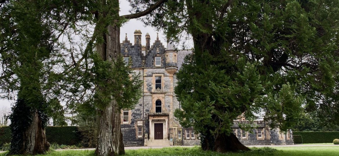 Blarney House, a Victorian mansion surrounded by lush green gardens in spring.