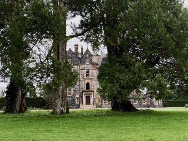 Blarney House, a Victorian mansion surrounded by lush green gardens in spring.